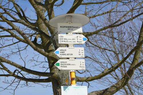 a pole with street signs in front of a tree at Chalupa v Hatích in Herálec