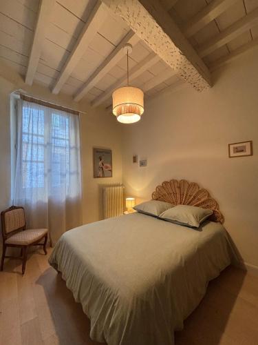 une chambre avec un grand lit et une fenêtre dans l'établissement Résidence Auguste - Centre historique Arles, à Arles