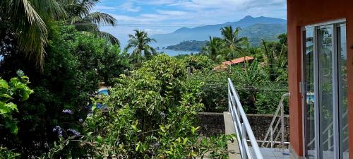 a balcony with a view of a garden at Suítes Cambucá in Ilhabela