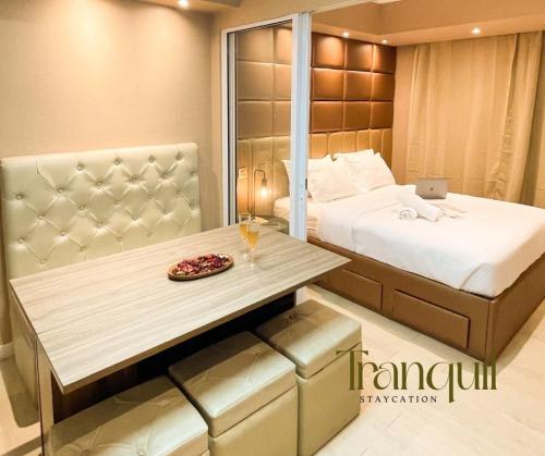 1 dormitorio con cama y mesa con ordenador portátil en Tranquil Staycation at Azure, en Manila