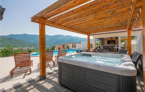 a hot tub on the patio of a house at Lovely Home In Vrgorac With Sauna in Vrgorac