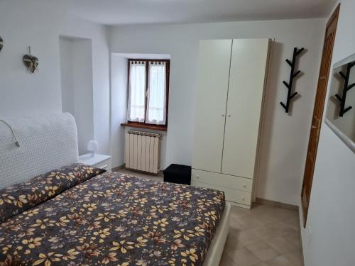 a bedroom with a bed and a cabinet and a window at Casa vacanze Castello in Frontone