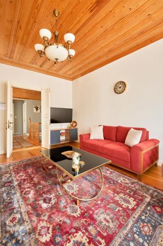 a living room with a red couch and a table at Nostalgic & Comfortable Historical Home! in Istanbul