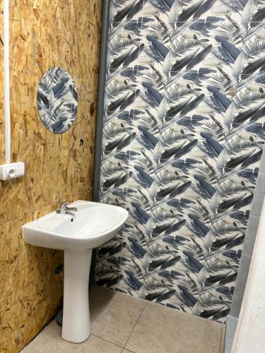 a bathroom with a sink and a tiled wall at Backpackers La Gaditana in Alhaurín el Grande