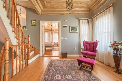 a living room with a staircase and a pink chair at Nostalgic & Comfortable Historical Home! in Istanbul