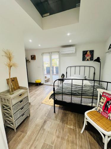 une chambre avec un lit et une chaise dedans dans l'établissement Petite maison indépendante proche Strasbourg, à Brumath