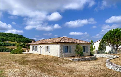 a small white house in a field with a yard at 4 Bedroom Gorgeous Home In Anthé in Anthé