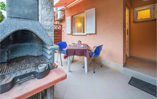 a patio with a table and an outdoor oven at Lovely Apartment In Banjole With Wifi in Banjole