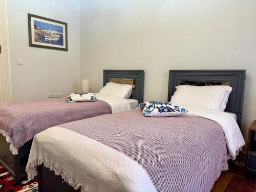 two beds in a room with white walls at Nostalgic & Comfortable Historical Home! in Istanbul