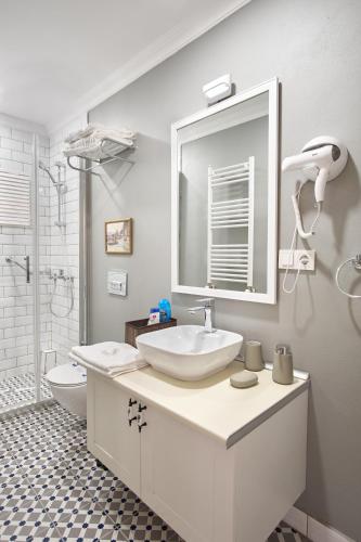 a white bathroom with a sink and a mirror at Nostalgic & Comfortable Historical Home! in Istanbul