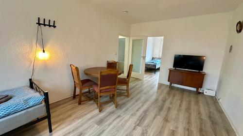 a room with a table and chairs and a television at MiCasa TuCasa - 3-R Apartment Leipziger Neuseenland Mira in Kitzscher
