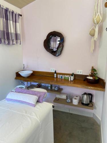 a room with a bed and a shelf on the wall at Pousada Lua Clara in Alto Paraíso de Goiás