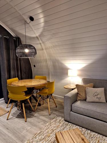 a dining room with a table and chairs and a couch at The Ness, Lodge with Hot Tub in Crieff