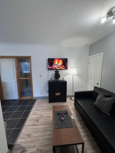 a living room with a couch and a tv on the wall at Modern Apartment good distance from Dublin City and Airport 4people in Dublin