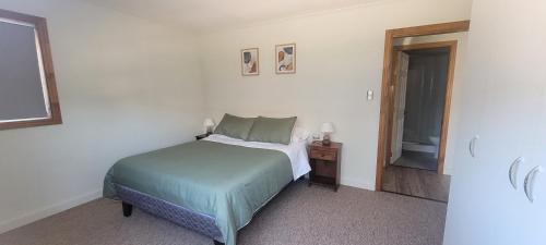 a bedroom with a bed and a door to a bathroom at Suites Oriente in Osorno