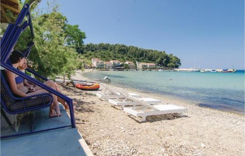 a woman sitting on a swing on the beach at Holiday Home Zuljana - 08 in Žuljana