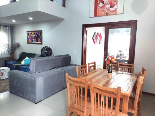 a living room with a table and a couch at Temporada Belas Casas in São Pedro