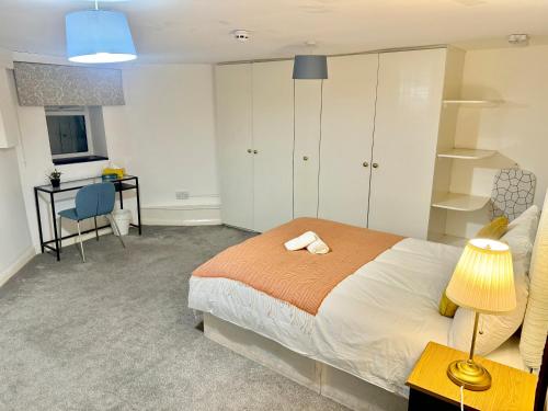 a bedroom with a bed and a desk and a table at Central London Private Bedrooms in Finsbury Park Station in London