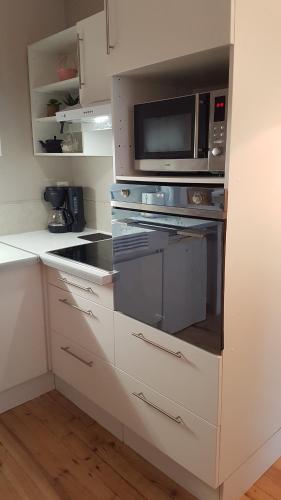 a kitchen with a stove and a microwave at Beaune Residence appartement in Beaune