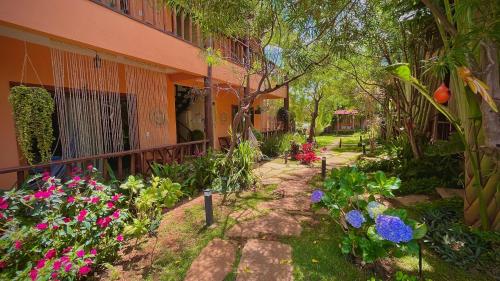 a garden in front of a house with flowers at Pousada Lua Clara in Alto Paraíso de Goiás