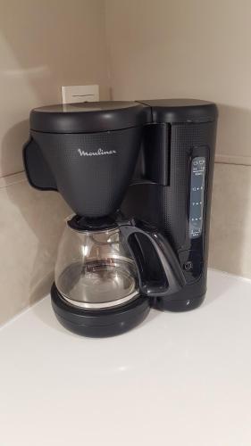 a black coffee maker sitting on top of a counter at Beaune Residence appartement in Beaune