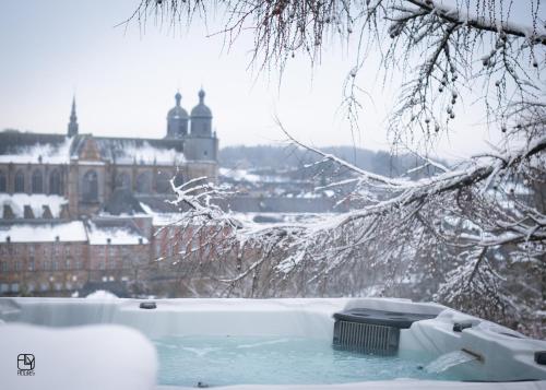 a bath tub with a view of a city in the snow at La St Hubsphair in Saint-Hubert