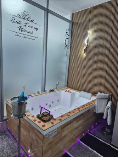 a large bath tub in a bathroom with a sign at Suite Luxury Niscemi in Niscemi
