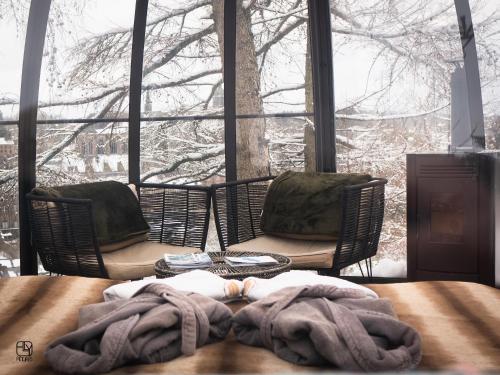 a blanket on a table in front of a window at La St Hubsphair in Saint-Hubert