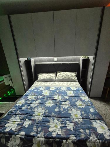 a bedroom with a bed with a blue and white comforter at Suite Luxury Niscemi in Niscemi