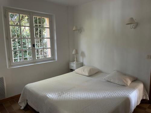 - un lit blanc dans une chambre avec fenêtre dans l'établissement Villa Sun&Sea, à La Croix-Valmer