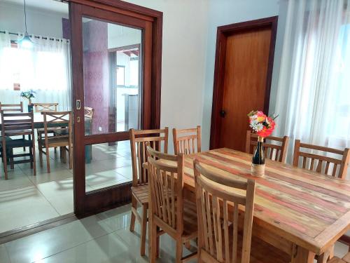 a dining room with a wooden table and chairs at Temporada Belas Casas in São Pedro