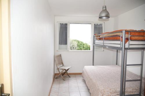une chambre avec un lit superposé et une fenêtre dans l'établissement Appartement Coté mer, à Canelle