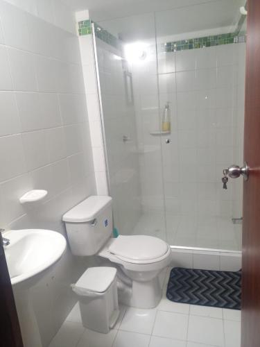 a white bathroom with a toilet and a shower at Lilia's House Santa Marta in Santa Marta