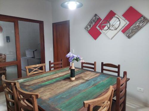 a dining room table with a vase of flowers on it at Temporada Belas Casas in São Pedro