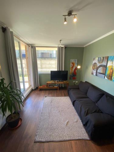 a living room with a couch and a tv at Departamento equipado en sector residencial in Osorno