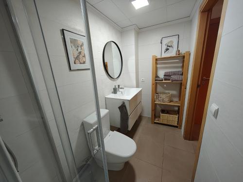 a bathroom with a toilet and a sink and a mirror at Estudio en primera linea de playa in Daimuz