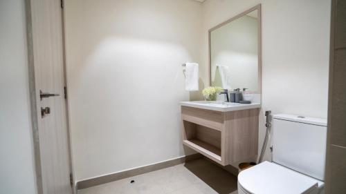 a bathroom with a toilet and a sink and a mirror at 4br Luxury Villa Yas Island Near F1 in Abu Dhabi