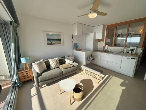 un soggiorno con un divano e un tavolo di Bel appartement vue mer a Palavas-les-Flots