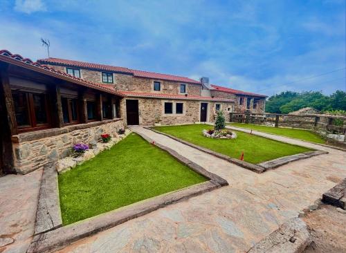 a house with a yard with green grass at Casita Meu Pai in Boimorto