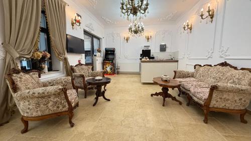 a living room with a couch and chairs and a chandelier at La Bulevard in Piteşti