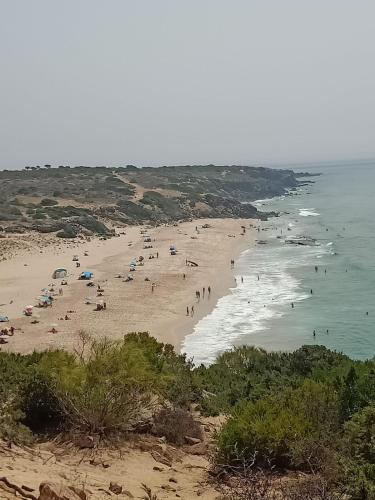 a group of people on a beach near the ocean at Playa y confort Zahara in Zahara de los Atunes