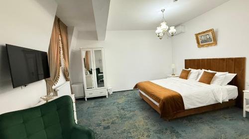 a bedroom with a bed and a flat screen tv at La Bulevard in Piteşti