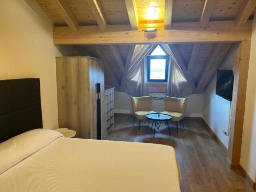 a bedroom with a bed and two chairs and a table at hotel la trainera in Pedreña