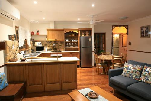 a kitchen and living room with a couch and a table at Lakefront holiday villa in Yungaburra