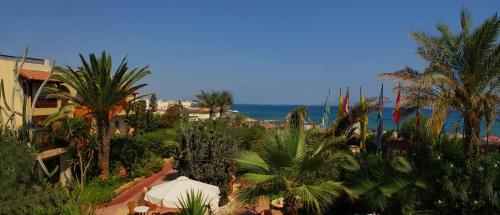 a view of a resort with palm trees and the ocean at Cactus Beach Hotel in Stalida