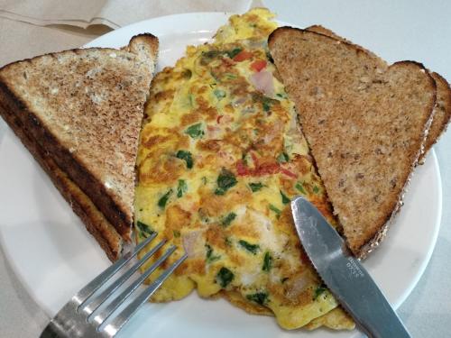 Twee stukken pizza op een bord met een vork en een mes. bij Niagara Creekside B&B - Waterfront suite in Niagara Falls