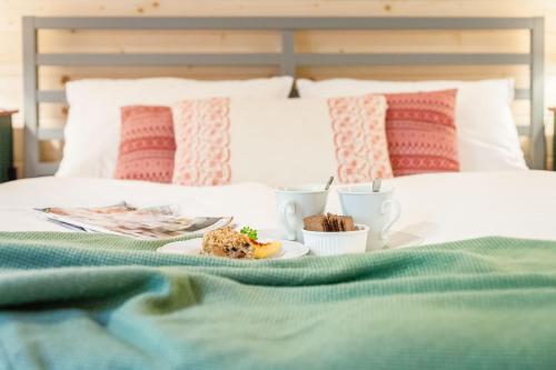 a breakfast plate of food on a bed at ŠTVRTÁ VODA - Jánska chata in Liptovský Ján