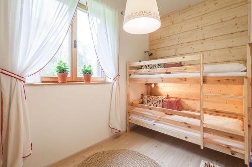 a bedroom with a bunk bed and a window at ŠTVRTÁ VODA - Jánska chata in Liptovský Ján