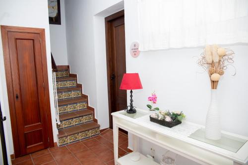 a room with a table with a lamp and stairs at Poniente in Roche