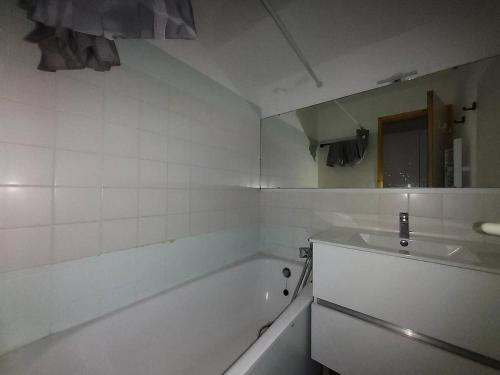 une salle de bain blanche avec une baignoire et un lavabo dans l'établissement Résidence Le Sextant - Appartement 2 pièces pour 6 personnes de 37m² MAE-0961, à La Plagne Tarentaise